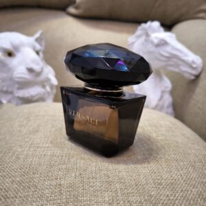 Side view of the Versace Crystal Noir Eau de Parfum bottle with a clean white background, showcasing its elegant dark glass design and signature crystal-inspired cap.